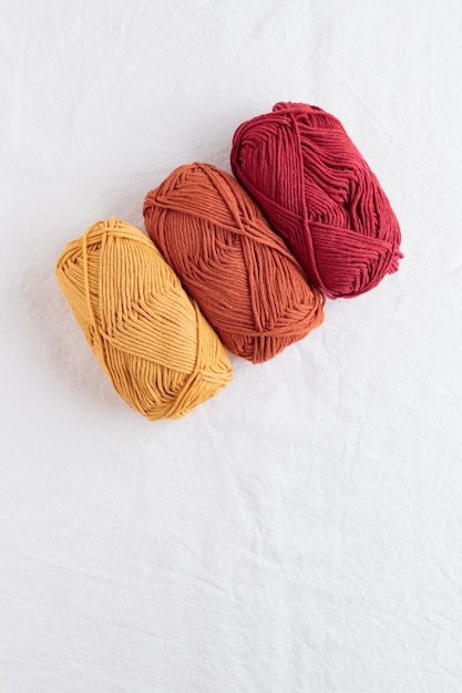 Balls of cotton yarn warm colors on a white table