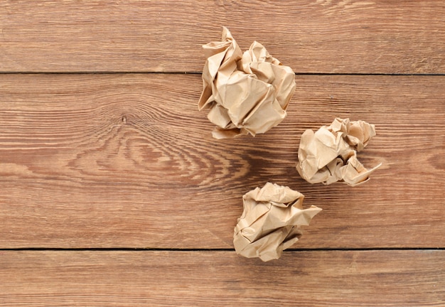 Balls of crumpled old paper on a wooden table. The concept of inappropriate, spent ideas.