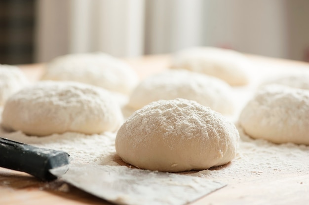 Balls of dough covered with wheat flour ready for baking