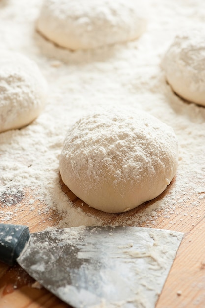 Balls of dough covered with wheat flour ready for baking