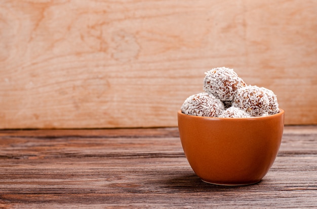 Balls of energy dates, nuts, oats, sprinkled with coconut powder close-up.