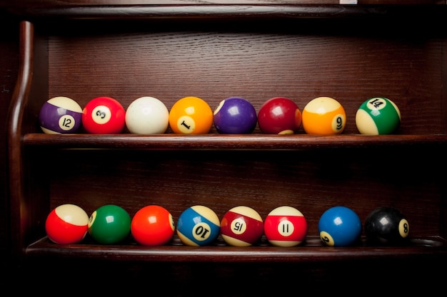 Balls for pool billiards on the shelf , billiard balls for American billiards , balls for Russian billiards , colored or white balls for billiards on a wooden background. Close-up photo. Soft focus.