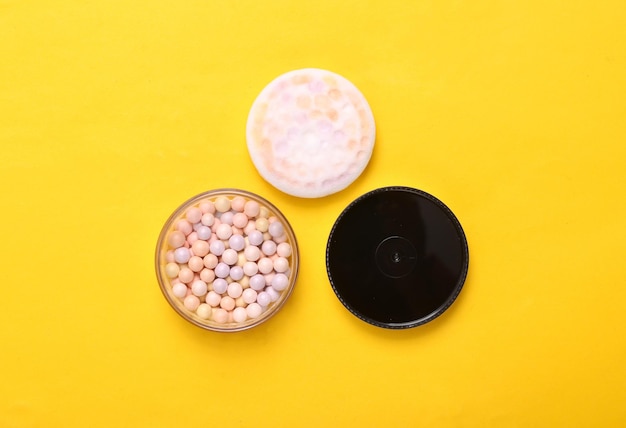 Balls of powder on a yellow background Cosmetics Top view