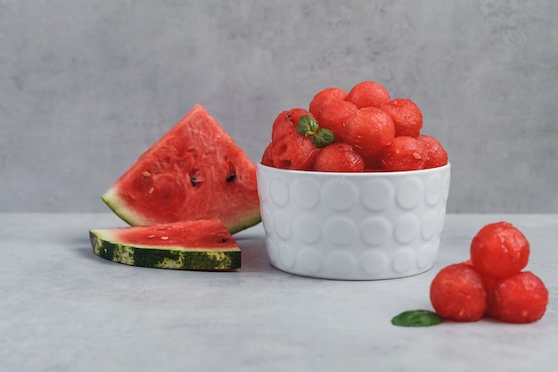 Balls of watermelon. Fruit salad with watermelon balls and mint in a white plate.