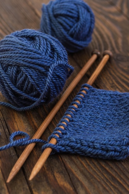 Balls of wool blue colors and knitting on wooden needles