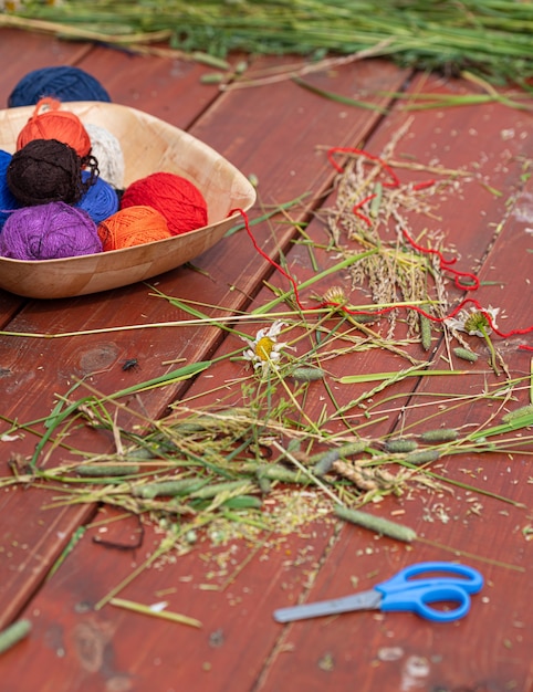 Balls of woolen yarn for knitting on a wooden table Knitting in nature Needlework in the garden