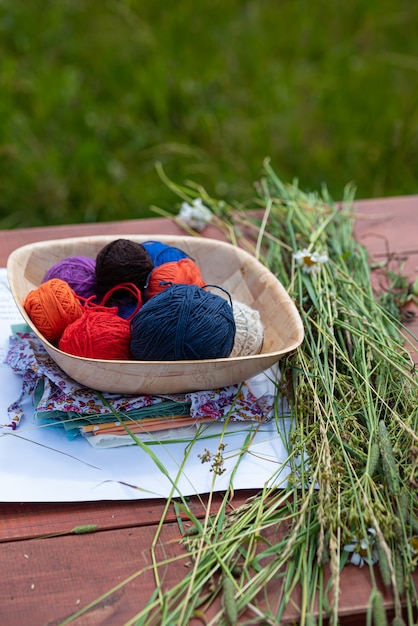 Balls of woolen yarn for knitting on a wooden table knitting in nature needlework in the garden