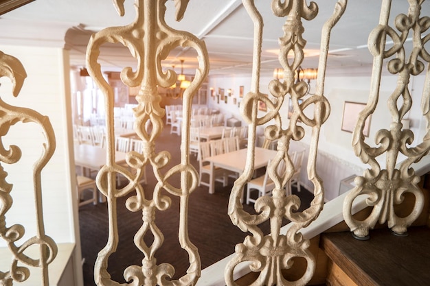 Balusters with pattern white tables and chairs interior of vintage restaurant spacious and comfortable