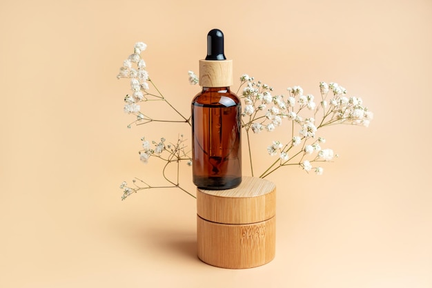 Bamboo cream jar and dropper bottle with face oil on a beige background Cosmetic container mockups Background for branding and packaging presentation Natural skincare beauty product concept