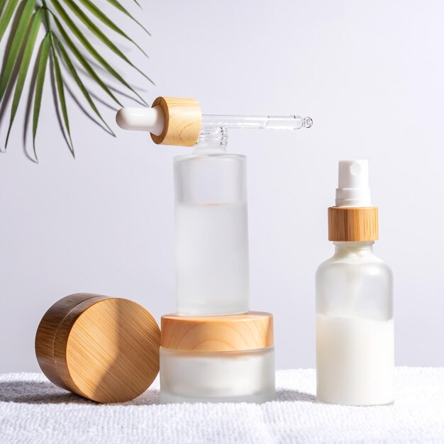 Bamboo cream jar and dropper bottle with face oil on a white background Cosmetic container mockups Background for branding and packaging presentation Natural skincare beauty product concept