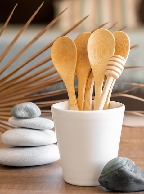 Bamboo spoons in cup on table disposable tableware from natural materials stones zero waste concept Place for text