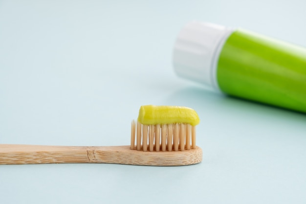 Bamboo toothbrush with green toothpaste on table