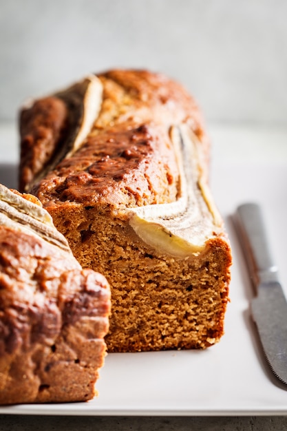 Banana bread on a gray plate, vertical photo. Healthy desserts concept.