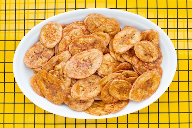 Banana chips on yellow background