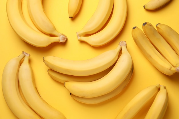 Banana clusters on yellow table. Fresh fruit