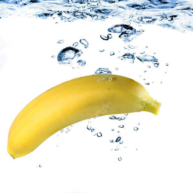 Banana dropped into water isolated on white