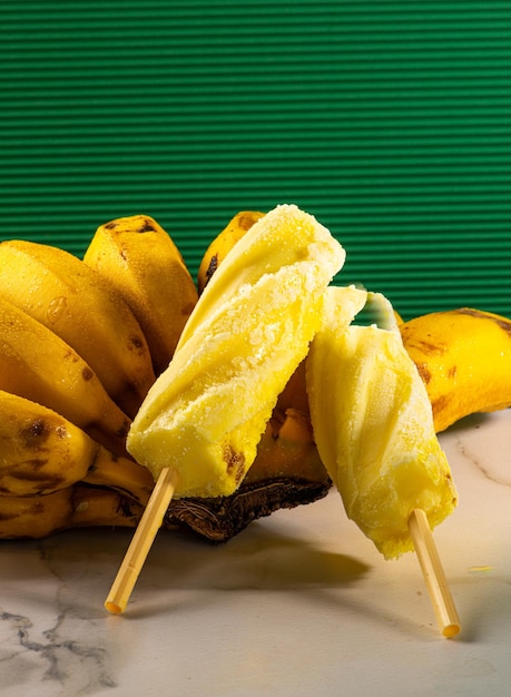 Banana ice cream supported on bunch of banana on white background