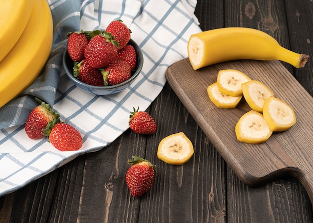 Banana and strawberries on a wooden board