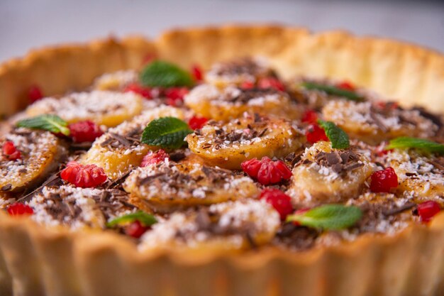 Banana yoghurt sponge cake with pieces of fresh fruit and chocolate on top