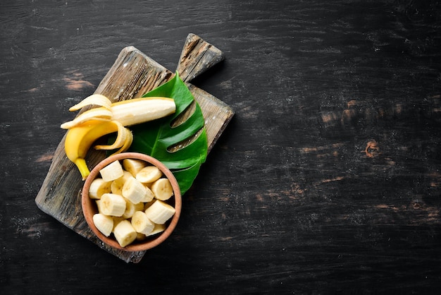 Bananas on a black wooden surface. Tropical Fruits. Top view. Free copy space.