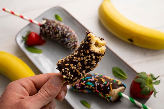 Bananas dipped in dark chocolate and covered with decorative caramel.