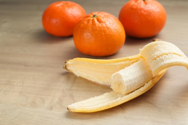 Bananas mandarines on wooden table Ripe fruit on the wooden table juicy fruits on wooden background