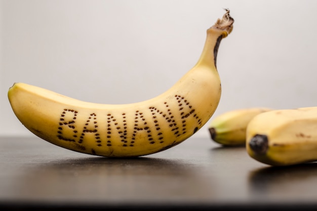 Bananas, on the peel of one of them is written the word