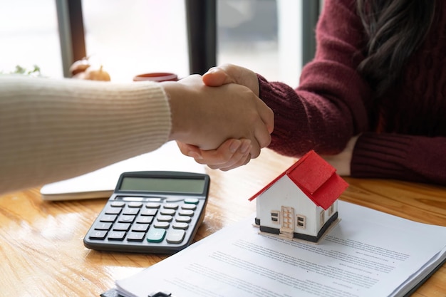 Photo the bank mortgage officer or real estate agent handshake with customer deal after signing a house insurance loan contract agreement