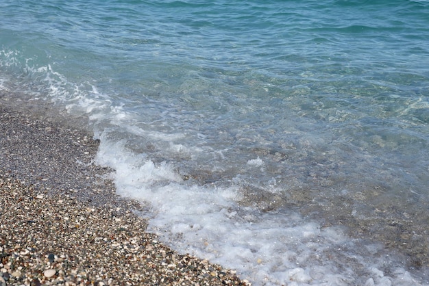 Bank of pebbles with the sea and beach in the background