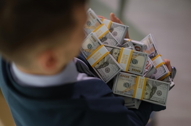 Banker holding in hands lot of packages with money closeup