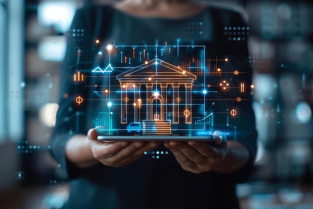 Banker holding a tablet with a holographic bank building icon and a financial graph icon