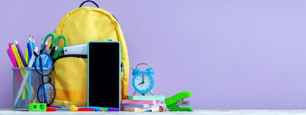 Banner Concept back to school Full tyelllow School Backpack with stationery on table