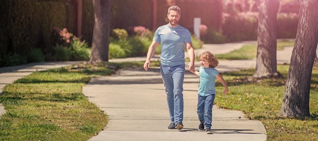 Banner of father and son walk cheerful dad with kid relax together in park family walk