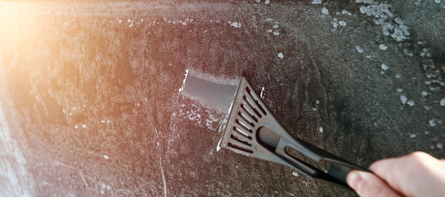 Banner image of removing ice from the car window Clearing the snow from the car after a heavy snowfall selective focus