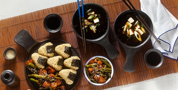 Banner of Japanese breakfast with miso soup onigiri and vegetables in sweet and sour sauce Typical traditional morning food