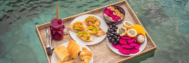 Banner long format breakfast tray in swimming pool floating breakfast in luxury hotel smoothies and