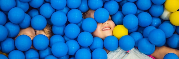 Banner long format child playing in ball pit colorful toys for kids kindergarten or preschool play