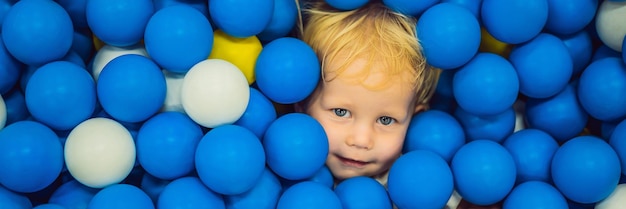 Banner long format child playing in ball pit colorful toys for kids kindergarten or preschool play