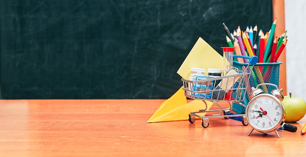 Banner school still life shopping cart with stationery on school board background university college