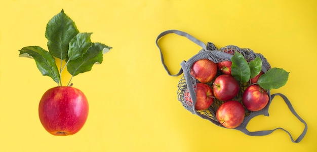 Banner Top view of mesh shopping bag with red apples and apple on the yellow background Copy space