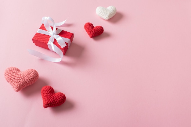 A banner for Valentine's Day made of knitted hearts is a gift on a pink background there is a place for text