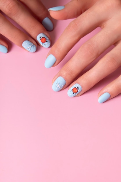 Banner with female hands with winter snow manicure with stickers under a matte top on pink background