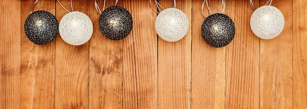 Banner with a garland of wicker balls on a wooden background.