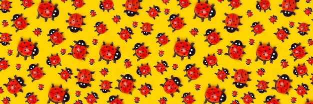 Banner with pattern of ladybugs on yellow background as backdrop or texture Bright summer wallpaper Top view Flat lay