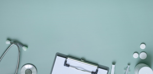 Banner with stethoscope syringes pills and tablet at doctor's workplace on colored background with copy space