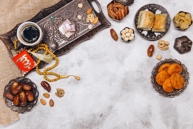 Banner with traditional Arabic dishes and food sets on it Koran and rosary Ramadan table top view