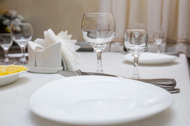 Banquet table served with instruments and decorated with empty wine glasses