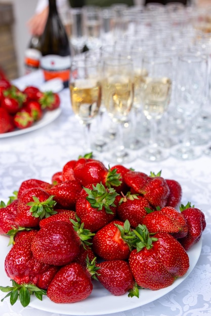 A banquet table with wine glasses and plates with strawberries