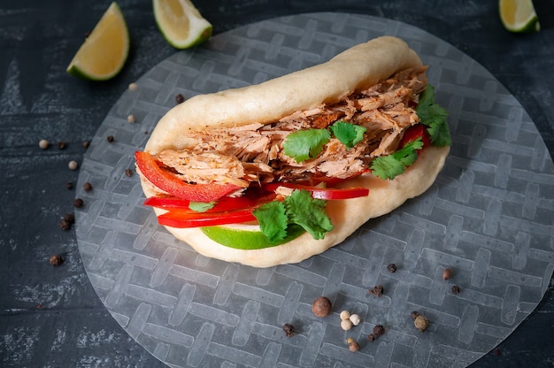 Bao burger with baked pork, sweet pepper, cilantro and lime.