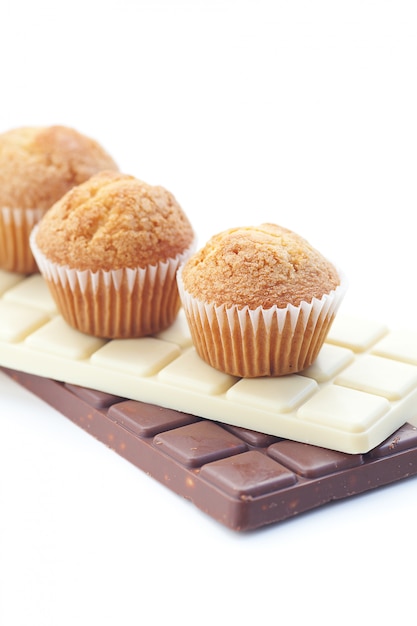 Bar of chocolate and muffin isolated on white